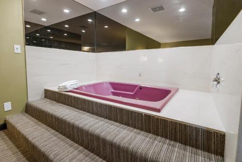 索诺拉Heritage Inn - Yosemite/Sonora的楼梯顶部的紫色浴缸