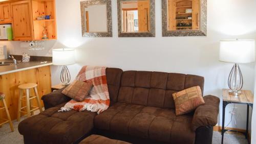 太阳峰Snow Creek Village #49的一间带棕色沙发的客厅和一间厨房