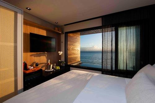 莫罗圣保罗Pousada Antonella的一间带大床的卧室,享有海景