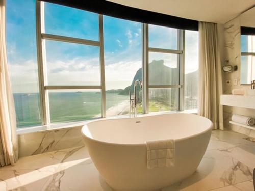 里约热内卢Hotel Nacional Rio de Janeiro的带浴缸的浴室和大窗户
