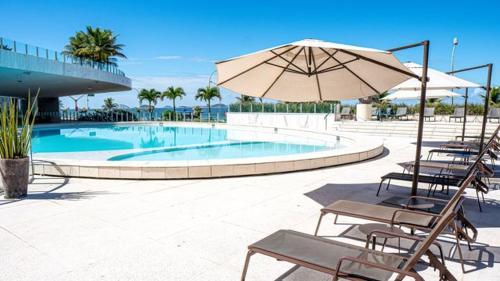 里约热内卢Hotel Nacional Rio de Janeiro的一个带椅子和遮阳伞的游泳池