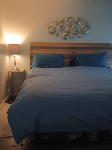 纳什维尔Nice & Near Downtown Nashville的一间卧室配有一张大床、蓝色床单和灯