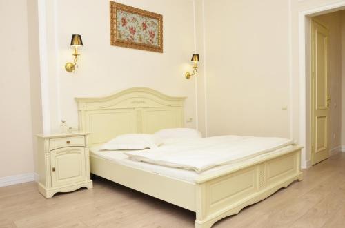 敖德萨Hotel Menshikov的一间白色卧室,配有床和床头柜