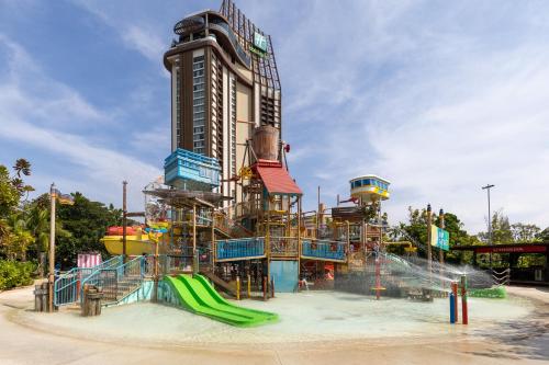 华欣华欣瓦纳纳瓦假日度假酒店的一座水上公园,在一座建筑前设有水滑梯