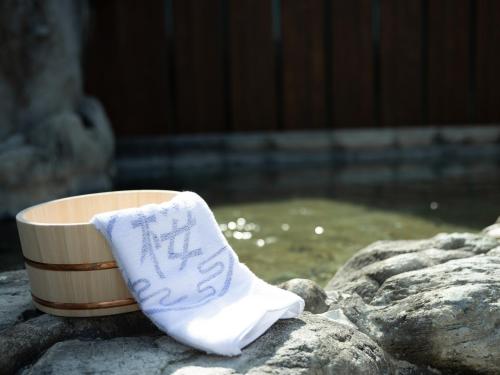 嬉野市Hotel Sakura Ureshino的坐在杯子旁的一块小石头上