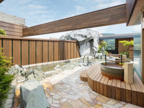 嬉野市Hotel Sakura Ureshino的一座位于房子中间的带一个浴缸的花园