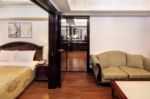 首尔江南新艺术城公寓的一间卧室配有一张床、一张沙发和一把椅子