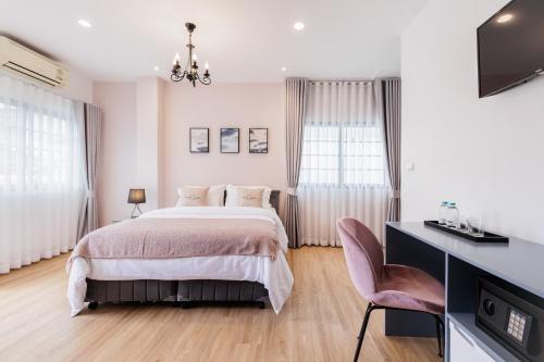 曼谷Casa Luna的一间卧室配有一张床和一张书桌及电视