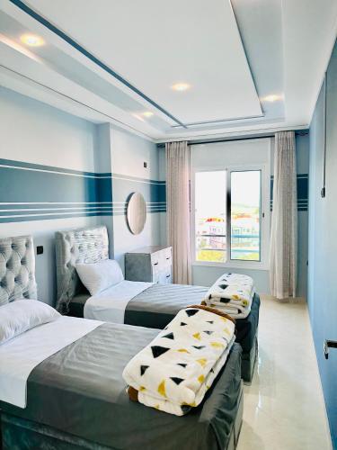 拉腊什Abraj Dubai Larache的一间卧室设有三张床和窗户。