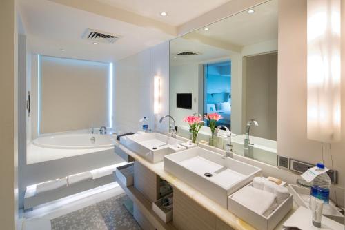 古尔冈古尔冈铂尔曼中央公园酒店的一间带两个盥洗盆和大镜子的浴室