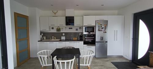 科利比塔Studio 1 Cabana de pe Stanca的厨房配有白色橱柜和桌椅