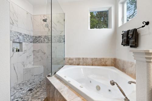 圣克鲁兹Gorgeous Santa Cruz Villa - Modern Beachside Paradise with NEW Hot Tub & Fast Wi-Fi的白色的浴室设有浴缸和淋浴。