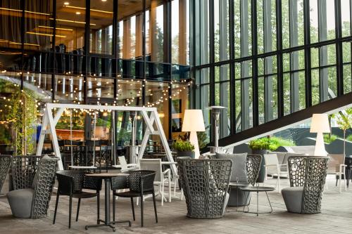 维尔纽斯维尔纽斯市中心万怡酒店的大楼内带桌椅的餐厅