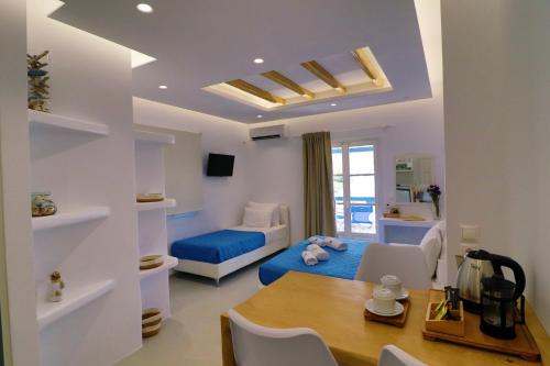 米科利维亚Coralli Beach Apartments的客厅配有蓝色的床和一张桌子