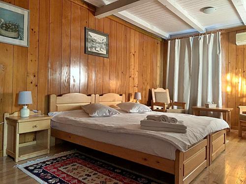 穆里吉奥尔Morena Mansion的一间卧室配有一张带木墙的大床
