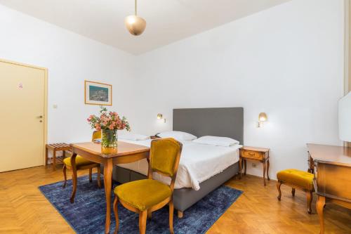 法扎纳Brijuni Rooms Karmen的卧室配有一张床和一张桌子及椅子
