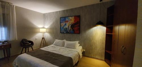 Bet HaKeremBLUE SKY的卧室配有一张床,墙上挂有绘画作品