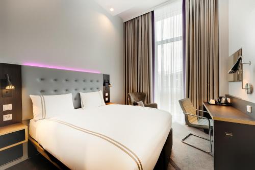 沃尔夫斯堡Premier Inn Wolfsburg City Centre的酒店客房设有一张大床和一张书桌。