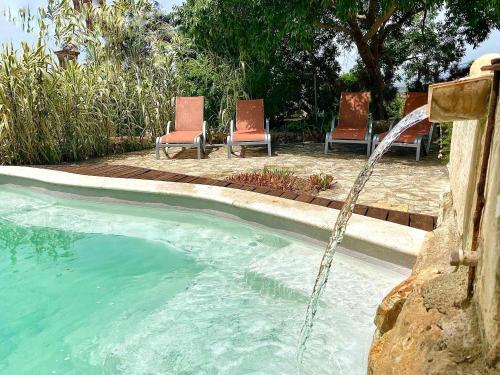 马拉特克西Asis de Marratxinet Turismo de Interior的一个带两把椅子的游泳池以及一个喷泉