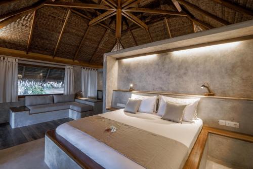 LikupangCoral Eye Boutique Resort and Marine Outpost的一间卧室配有一张大床和一张沙发