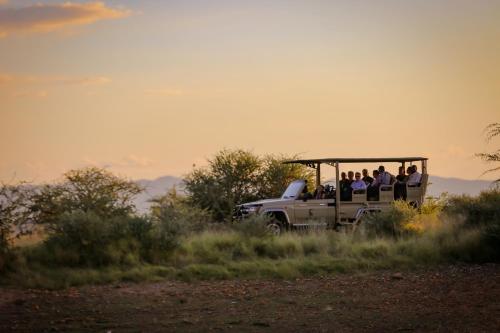 温特和克Okapuka Safari Lodge的一群人骑在卡车后面