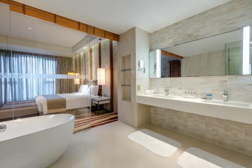 上海上海大华虹桥假日酒店的带浴缸、水槽和床的浴室