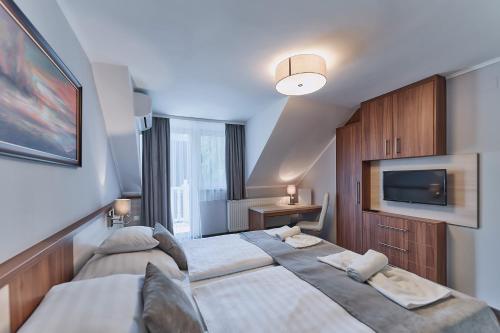 凯斯特海伊托卡耶尔康体酒店的一间卧室配有两张床和一台平面电视