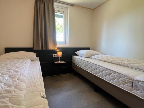 OpheusdenVakantiehuis 6 personen的带窗户的客房内设有两张单人床。