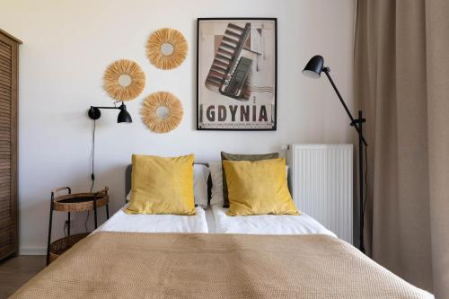 格丁尼亚Symphony Modern Tower Aparthotel的一间卧室配有一张带黄色枕头的床