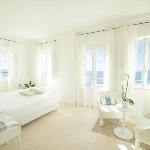 斯库索港Relais La Ghinghetta的白色卧室配有床和椅子