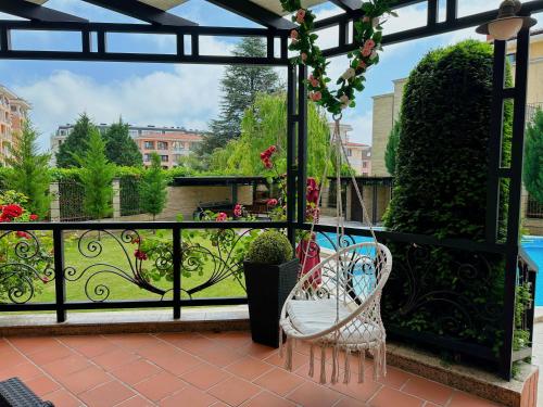 圣君士坦丁和海伦那Family Hotel Paradise的阳台配有两把椅子,享有花园的景色