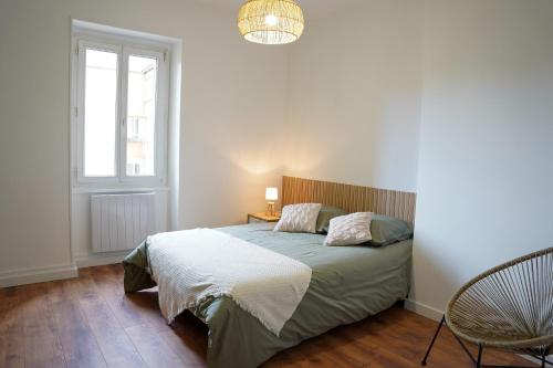 布雷斯地区布尔格Appart Lumineux 150 m de la Gare的一间卧室设有一张床、一个窗口和一把椅子