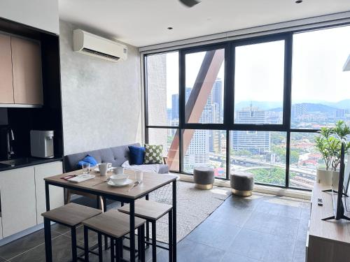 吉隆坡Infinity Pool Scarletz Suites KLCC的厨房以及带桌子和大窗户的客厅。