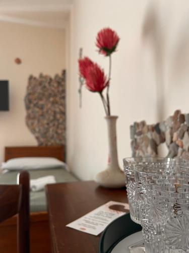贾迪尼-纳克索斯Sole Mare B&B的一张桌子,上面有花瓶,上面有红花