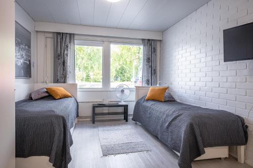 图里Tuurin Yösäilö的一间卧室设有两张床和窗户。