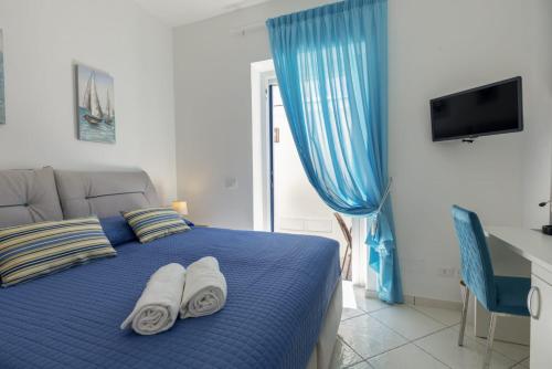 伊斯基亚Casa Borgo Sant'Angelo的一间卧室配有蓝色的床和毛巾