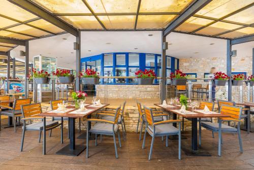 法扎纳Brijuni Hotel Neptun的一间带桌椅和鲜花的餐厅