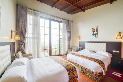 KisoroGorilla Heights Lodge的一间卧室设有两张床和大窗户