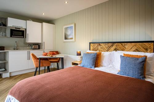 WinsterComfy Lake District Cabins - Winster, Bowness-on-Windermere的一间卧室配有一张床,厨房配有桌子