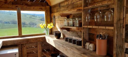 吉斯本Little Middop Farm Camping Pods的厨房设有窗户和带瓶子的柜台。