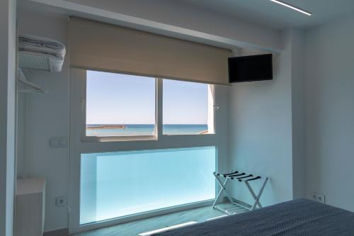 佩尼斯科拉Hostal Boutique La Mar Serena的一间卧室设有海景窗户