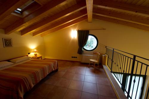维罗纳自由镇Agriturismo Il Melograno的一间卧室设有一张床和一个大窗户