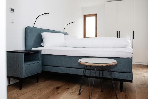 埃伦豪森Design Appartements Ehrenhausen的一间卧室配有一张带凳子和桌子的床