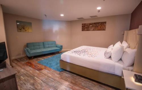 马姆莫斯湖Empeiria High Sierra Hotel的一间卧室配有一张床和一张蓝色的沙发