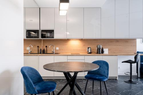 弗罗茨瓦夫RentPlanet - Apartamenty OVO的厨房配有木桌和蓝色椅子