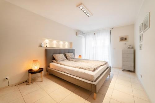 拉塔Apartament 37 Międzymorze 10的卧室配有一张床和一盏灯,铺有瓷砖地板。