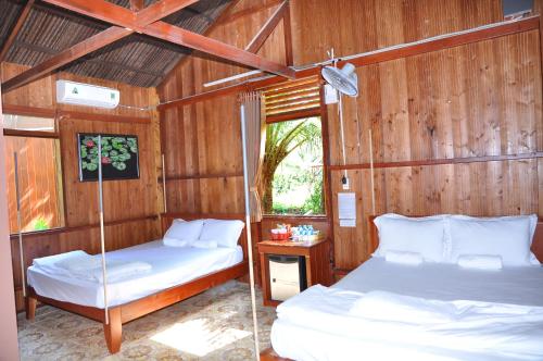 槟知Homestay Xóm Dừa Nước的木墙客房的两张床