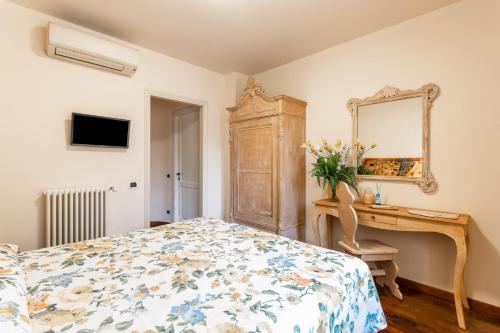 马尔米堡Villa Diletta b&b的一间卧室配有一张床、一张书桌和一面镜子