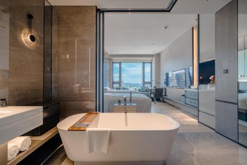武汉武汉光谷万豪酒店的一间带白色浴缸和大窗户的浴室