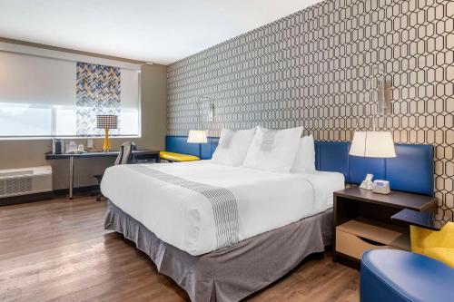 萨凡纳GLō Best Western Savannah-Gateway I-95的酒店客房设有一张大床和一张书桌。